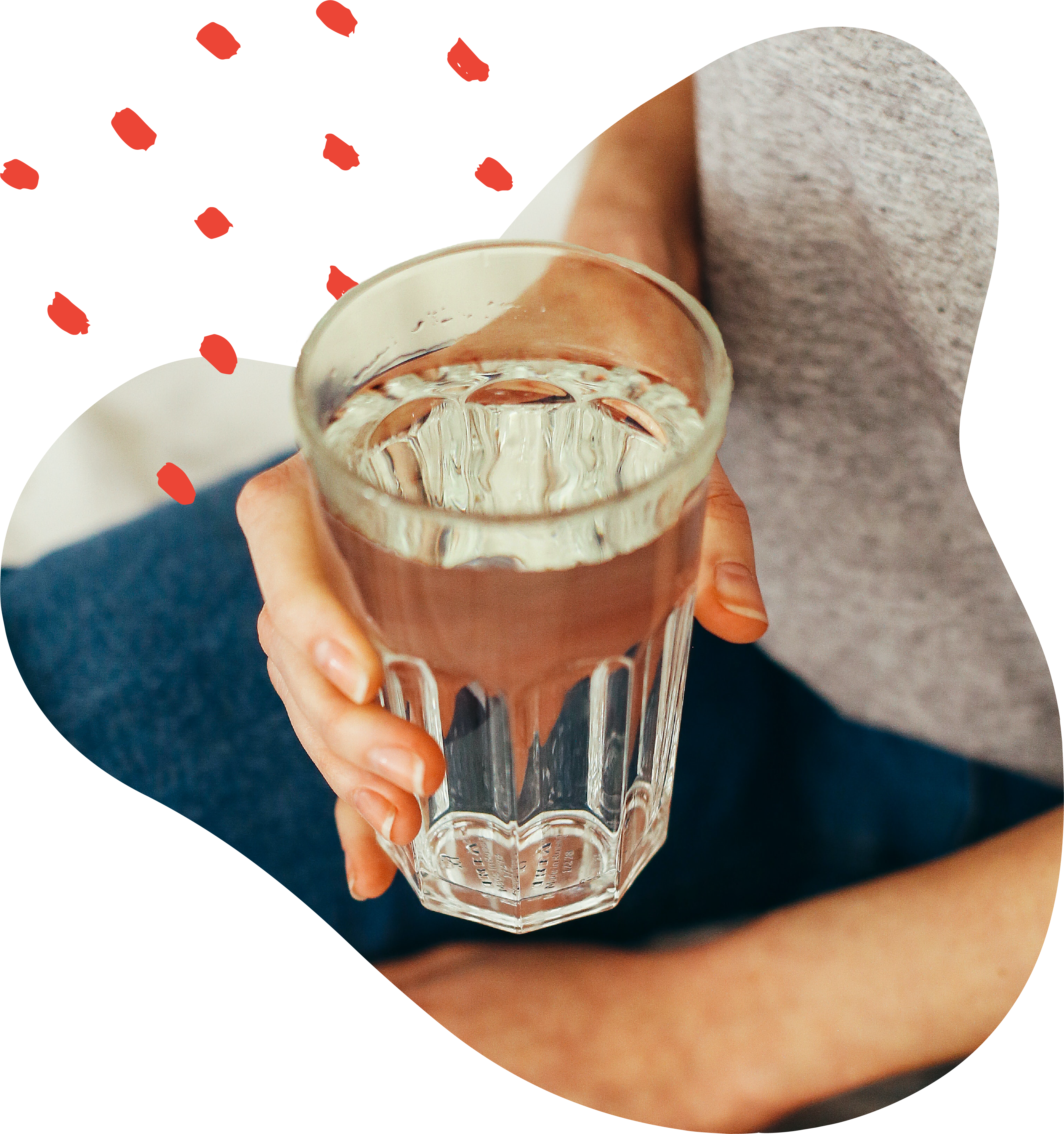 Woman sits on bed holding full glass of water